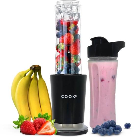 Realistische afbeelding van de Cook-IT personal smoothie maker. De blender is gevuld met kleurrijke ingrediënten zoals aardbeien, blauwe bessen, bananen en ijsblokjes. Naast de blender staan twee to-go bekers, gevuld met een roze smoothie, omringd door vers fruit zoals aardbeien, bananen en blauwe bessen. De witte achtergrond benadrukt het compacte en draagbare ontwerp.